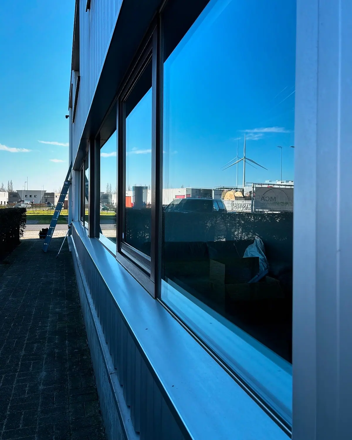 Brede pui van bedrijfspand weerspiegelt blauwe lucht na osmose-reiniging