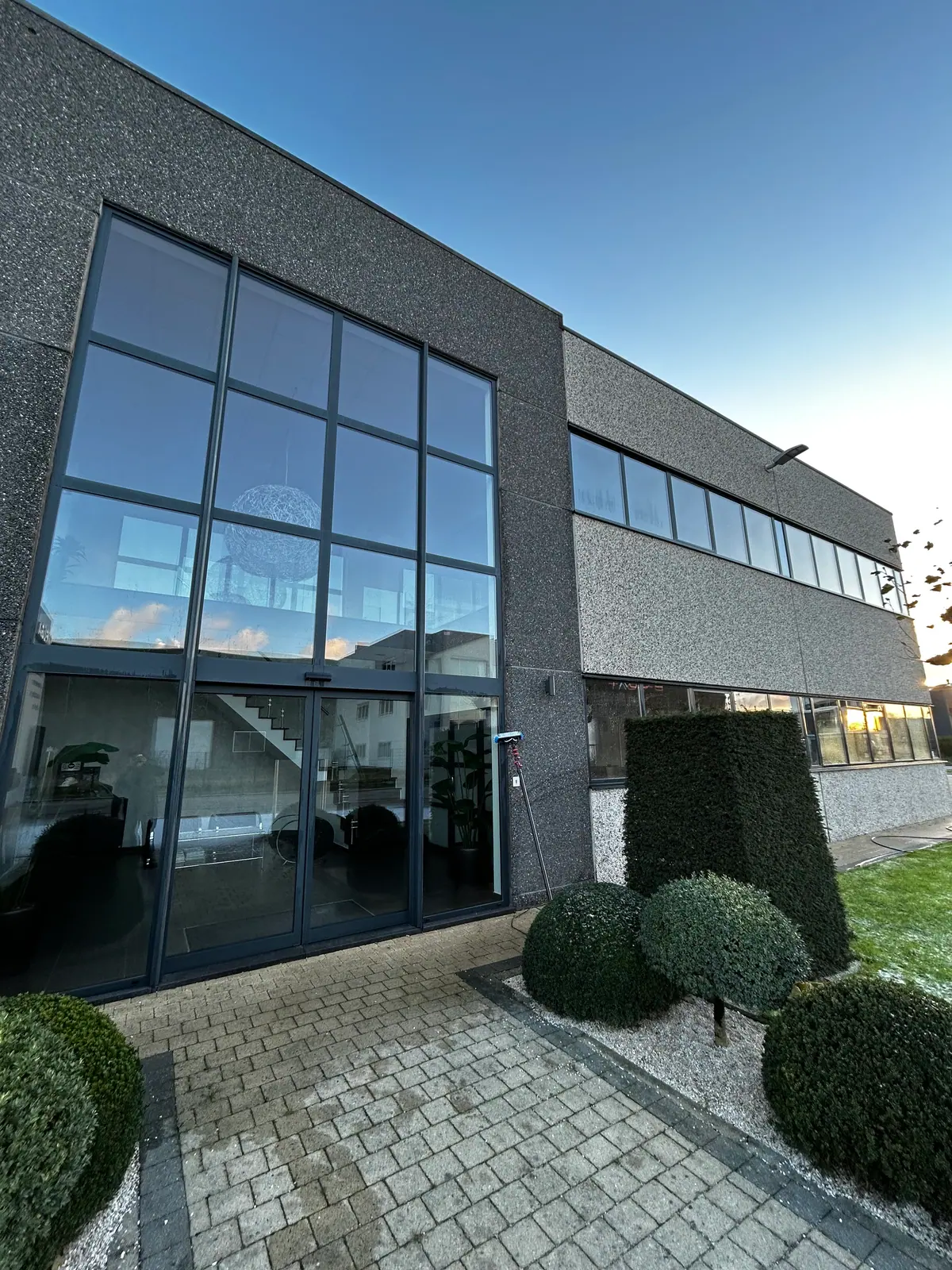 Moderne donkere woning met grote gridded ramen na reiniging door Yuslina